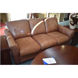 Full sized distressed light brown leather sofa