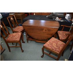 Mid 20th century walnut drop leaf, gate leg table with four side chairs featuring upholstered seats 