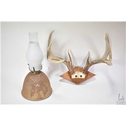 Pair of mounted antlers and a clay oil lamp