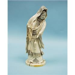 A well carved antique Japanese ivory figure of a lady in cer