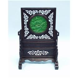 A well carved jade table screen depicting a winding dragon f