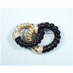 A stylish 18 kt. yellow gold, black onyx and diamond brooch.