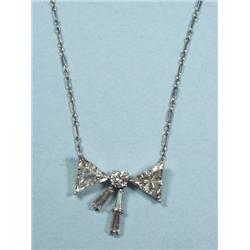 A handmade platinum and diamond bow pendant on a platinum ch
