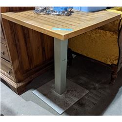 a teak bar table with metal base from the scifi show