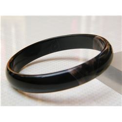 A NATURAL BLACK AGATE BANGEL.