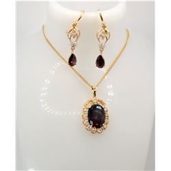25)  GOLD TONE, CLEAR AND GARNET RED OVAL