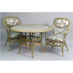 A POLYCHROME RATTAN AND FLORAL UPHOLSTERED CIRCULAR BREAKFAST TABLE