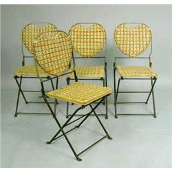 A SET OF FOUR POLYCHROME-DECORATED HEART-BACK FOLDING GREEN-PAINTED METAL CHAIRS