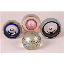 A GROUP OF FOUR GLASS PAPERWEIGHTS