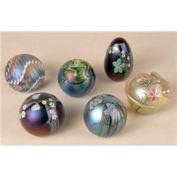A GROUP OF SIX IRIDESCENT GLASS PAPERWEIGHTS