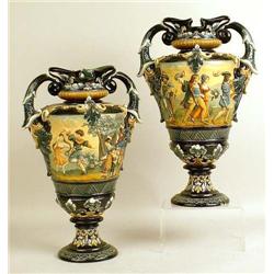 A PAIR OF FOOTED HANDLED POLYCHROME DECORATED MAJOLICA URNS