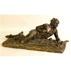 A CAST BRONZE SCULPTURE OF A RECUMBENT NATIVE AMERICAN