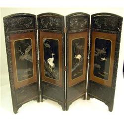 A MOTHER-OF-PEARL INLAID BROWN AND BLACK LACQUERED CARVED HARDWOOD FOUR-PANEL SCREEN