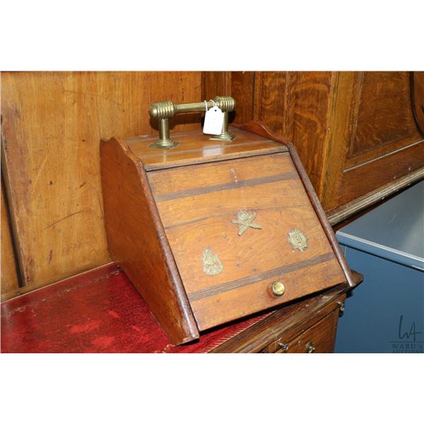 Antique walnut coal hod adorned with brass military insignia