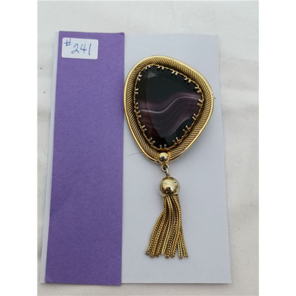 Articulated gold tone broach with purple glass