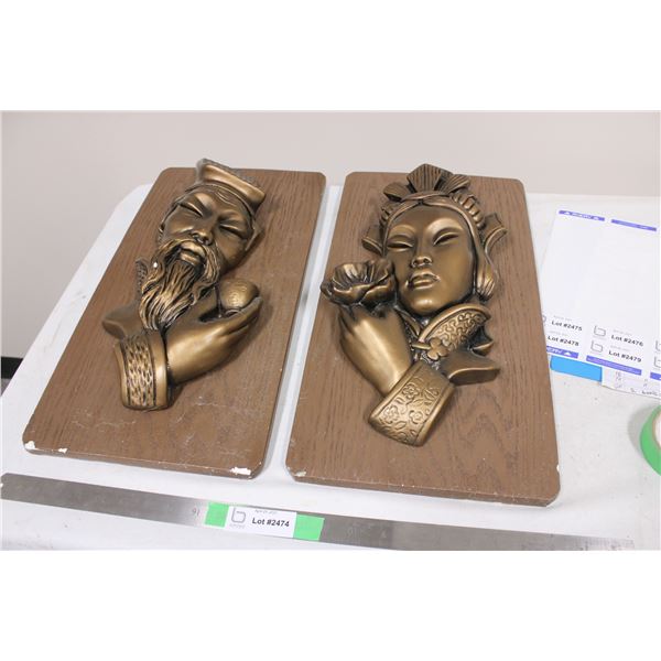 Statue Heads Hanging on Wooden Plaque