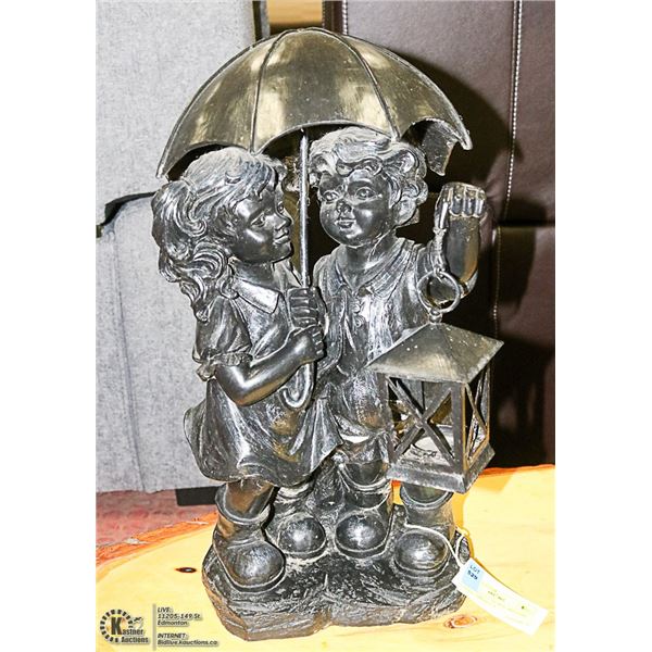 BLACK STATUE OF BOY AND GIRL UNDER UMBRELLA