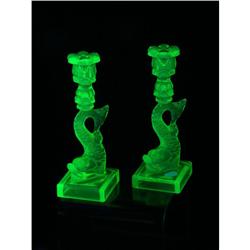 A PAIR OF VASELINE GLASS DOLPHIN MMA CANDLESTICKS