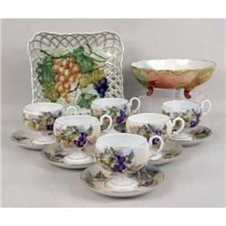 SIX POLYCHROME-DECORATED PORCELAIN FOOTED CUPS AND SAUCERS