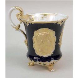 A COBALT PARCEL-GILT DECORATED PORCELAIN FOOTED HANDLED CUP