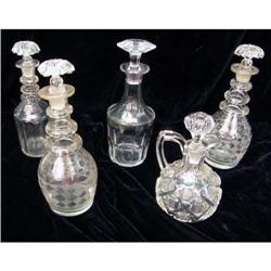 A GROUP OF COLORLESS GLASS CRUETS WITH STOPPERS