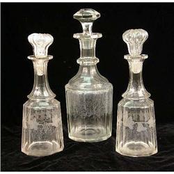 THREE COLORLESS GLASS STOPPERED DECANTERS