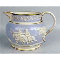 A LAVENDER AND CREAM DECORATED PARCEL GILT HUNTING SCENE EMBOSSED CERAMIC PITCHER