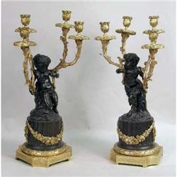 A PAIR OF GILT-BRONZE AND EBONIZED CLASSICAL-THEMED CANDELABRA