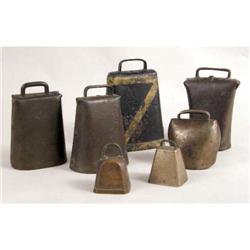 A GROUP OF SEVEN COW BELLS