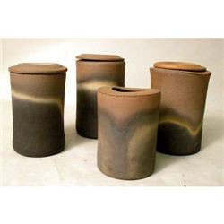 A SET OF FOUR GLAZED REDWARE GRADUATED CANISTERS