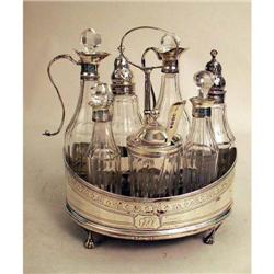 AN ENGLISH STERLING SILVER-HANDLED CRUET STAND WITH SEVEN GLASS BOTTLES