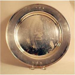 A STERLING SILVER CIRCULAR CHARGER WITH CENTRAL CREST