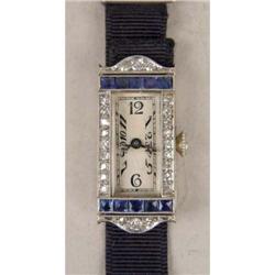AN 18 KT. ART DECO E. HUGUENIN 17 JEWELS WHITE GOLD SAPPHIRE AND DIAMOND LADY`S WRISTWATCH