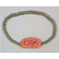 AN ANTIQUE 14KT YELLOW GOLD CARVED CORAL PENDANT SUSPENDED FROM YELLOW GOLD CHAIN