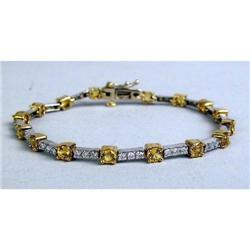 A 14K YELLOW AND WHITE GOLD DIAMOND AND YELLOW SAPPHIRE LINE BRACELET