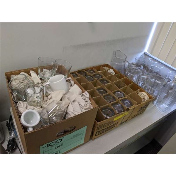 Table top of assorted glassware, coffee mugs, beer glasses, jugs etc.