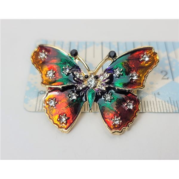 17)  GOLD TONE WITH MULTI COLORED ENAMEL AND CLEAR & BLACK CRYSTAL BUTTERFLY BROOCH.