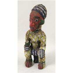 AN AFRICAN BEADED FIGURE OF A SEATED PERSON