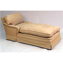 A BEIGE UPHOLSTERED CHAISE LOUNGE