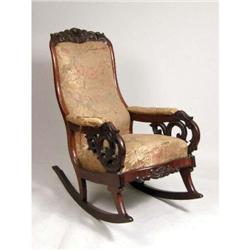 A VICTORIAN CARVED MAHOGANY PARLOR ROCKING CHAIR