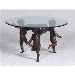 Beveled glass topped coffee table with a trio of spelter prancing putti