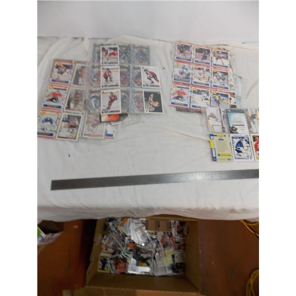 Box with loose hockey cards inside + loose pages of cards