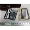 Image 2 : Combination locking suitcase (unknown combination) + misc pens + calculators