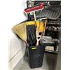 Image 1 : Black plastic trash bin-filled w/assorted brooms and shovels