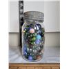 Image 1 : Assorted large and small fancy marbles in a mason jar.