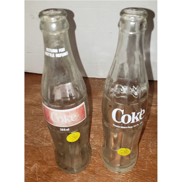 two coca cola glass bottles