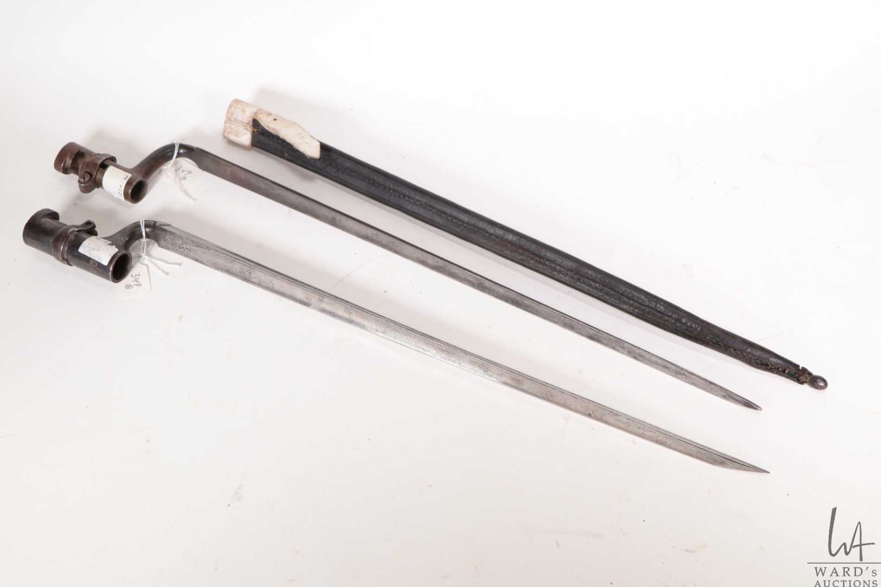 Two Enfield style triangular bayonets, one with leather scabbard and ...