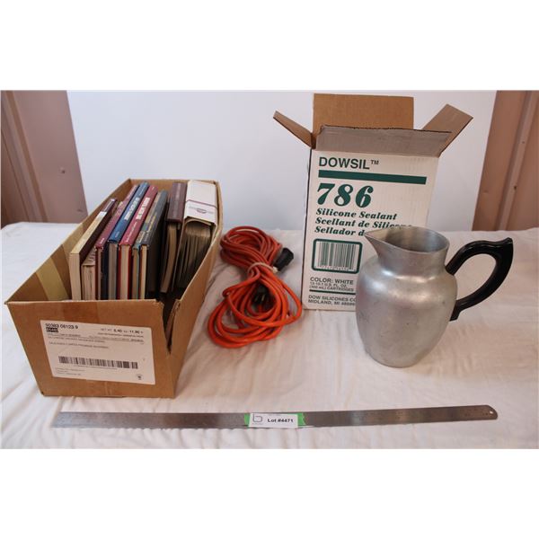 Box of light switches and plugs, metal milk jug, extention cord, and cookbooks