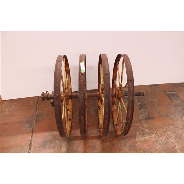 set of four cast iron farm implement wheels on axel 33” long 25” wheel diameter