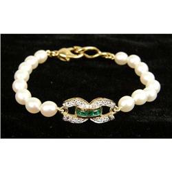 A PEARL BRACELET WITH DIAMOND AND EMERALD DOUBLE HORSESHOE MOTIF PLAQUE
